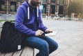 Hipster texting message on tablet computer or technology blank screen mockup. Smile young man with backpack using digital