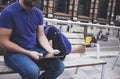 Hipster texting message on tablet computer or technology screen mockup. Smile young man using digital on building castle