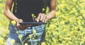Hipster texting message on tablet or technology, mock up of blank screen. Girl using computer on yellow flowers background close Royalty Free Stock Photo