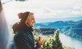 Hipster tourist hold in hands mug of hot drink, lonely guy smile enjoy sun flare mountain in auto, happy traveler drink cup of tea
