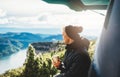 Hipster tourist hold in hands mug of hot drink, lonely smile guy enjoy sun flare mountain in auto, traveler drink cup of tea