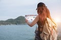 Hipster tourist hold and look map on trip, lifestyle concept adventure, traveler with backpack on mountain and blue sea landscape Royalty Free Stock Photo