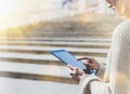 Hipster tourist texting message on tablet or technology mock up. Person using computer on building background close. Female hands