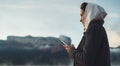 Hipster tourist using smartphone on foggy lake, mist in mountain nature, traveler girl hold mobile phone, enjoy wifi internet