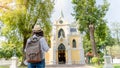 Hipster tourist wearing white shite and hat on trip, traveler with backpack on background temple