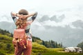 Hipster traveler with backpack enjoying view at mountains in fog