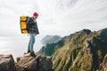 Hipster traveler with backpack standing on the edge cliff rock. Lifestyle adventure wanderlust Royalty Free Stock Photo