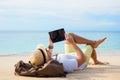 Hipster traveler on the beach with tablet computer