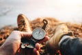 Hipster traveler sitting and hold in hand compass. POV view. Blurred background