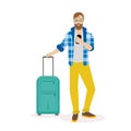 Hipster traveling man standing with suitcase and looking at mobile phone. Traveling man with suitcase using mobile phone