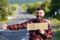 Hipster try to stop car with cardboard sign, thumb up