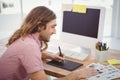 Hipster using graphics tablet while working at desk Royalty Free Stock Photo