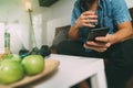 hipster using smart phone and digital tablet computer and holding credit card payments online business,sitting on sofa in living