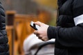 Hipster using a touch screen smart phone hands close up, vintage colors. Man using mobile smartphone - focus on top of the phone. Royalty Free Stock Photo