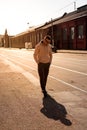 Hipster walking in the street with red brick wall building in summer day. Royalty Free Stock Photo