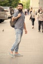 Hipster wearing backpack urban street background. Bearded man travel with backpack. Guy exploring city. Comfortable Royalty Free Stock Photo