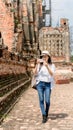 Hipster woman wearing white shirt and hat taking photo by mobile in temple ayutthaya thailand, Travel Holiday Relaxation Concept Royalty Free Stock Photo