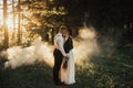 Hipster wedding couple kissing in forest in sunset light in fog Royalty Free Stock Photo