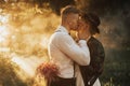 Hipster wedding couple kissing in forest in sunset light in fog Royalty Free Stock Photo