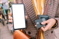 woman with a Bank card and smartphone in her hands performs secure transactions through financial application, outdoors Royalty Free Stock Photo