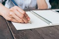 Hipster woman hand writing notebook paper in coffee shop. Royalty Free Stock Photo