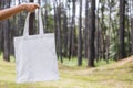 hipster woman holding white cotton bag at park Royalty Free Stock Photo