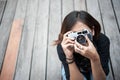 Hipster woman taking photos with retro film camera on wooden floorof city park,beautiful girl photographed in the old camera Royalty Free Stock Photo