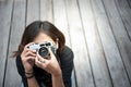 Hipster woman taking photos with retro film camera on wooden floorof city park,beautiful girl photographed in the old camera Royalty Free Stock Photo