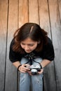 Hipster woman taking photos with retro film camera on wooden floorof city park, beautiful girl photographed in the old camera Royalty Free Stock Photo