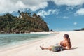 Hipster woman traveler with backpack on the coast enjoying island view. Royalty Free Stock Photo