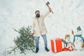 Hipster woodsman with Christmas tree. Man is going to cut a Christmas tree. Christmas tree cut. Bearded Man cutting