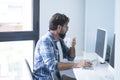 Hipster worker man witting at the desk with online modern job. Adult at work in white bright office with computer and internet