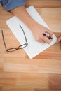 Hipster writing in paper at desk Royalty Free Stock Photo