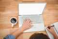 Hipster writing on spiral book using laptop Royalty Free Stock Photo