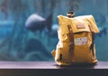 Hipster yellow backpack and map closeup. View from front tourist traveler bag on background blue sea aquarium. Person hiker visiti Royalty Free Stock Photo