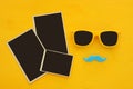 Hipster yellow sunglasses and funny moustache next to blank photographs Royalty Free Stock Photo