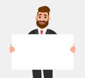 Hipster young business man showing blank white poster/paper copy space area. Cheerful trendy person holding empty banner. Royalty Free Stock Photo