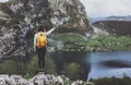 Hipster young girl with backpack enjoying sunset on peak of foggy mountain, looking on lake and poining hand. Tourist traveler Royalty Free Stock Photo