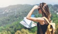 Hipster young girl with bright backpack enjoying panoramic mountain sea, using map and looking distance. Tourist traveler on back Royalty Free Stock Photo