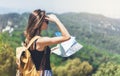 Hipster young girl with bright backpack enjoying panoramic mountain sea, using map and looking distance. Tourist traveler Royalty Free Stock Photo