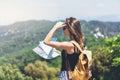 Hipster young girl with bright backpack enjoying panoramic mountain sea, using map and looking distance. Tourist traveler Royalty Free Stock Photo