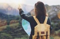 Hipster young girl with bright backpack enjoying sunset on peak of foggy mountain, looking a map and poining hand. Tourist travel Royalty Free Stock Photo