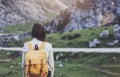 Hipster young girl with bright backpack enjoying sunset on peak of foggy mountain. Tourist traveler on background valley landscape Royalty Free Stock Photo