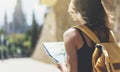 Hipster young girl with bright backpack and fashion sunglasses looking at map. Said view tourist traveler on background sun city