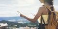 Hipster young girl with bright backpack looking at a map and poining hand the travel plan. View from the back of tourist travel Royalty Free Stock Photo