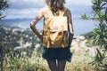 Hipster young girl with bright backpack looking at a map and poining hand the travel plan. View from the back of the tourist Royalty Free Stock Photo