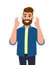 Hipster young man showing hopeful gesture sign with fingers crossed. Trendy bearded person making believe or wish symbol