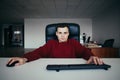 Hipster young man working in the office at the computer. Close look at the camera Royalty Free Stock Photo