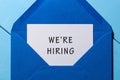 We are hiring phrase written in the paper at blue envelope. human resources concept