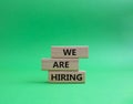 We are Hiring symbol. Concept words We are Hiring on wooden blocks. Beautiful green background. Business and We are Hiring concept